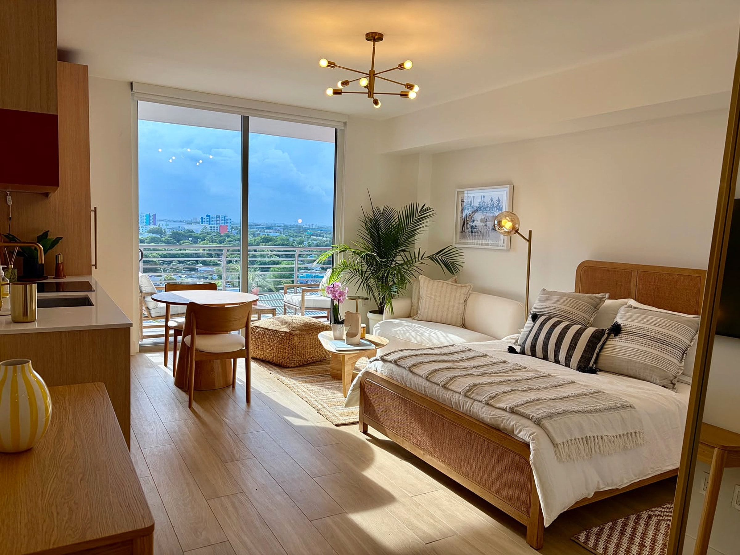 Bedroom and living area together at dusk, with Midtown Miami view