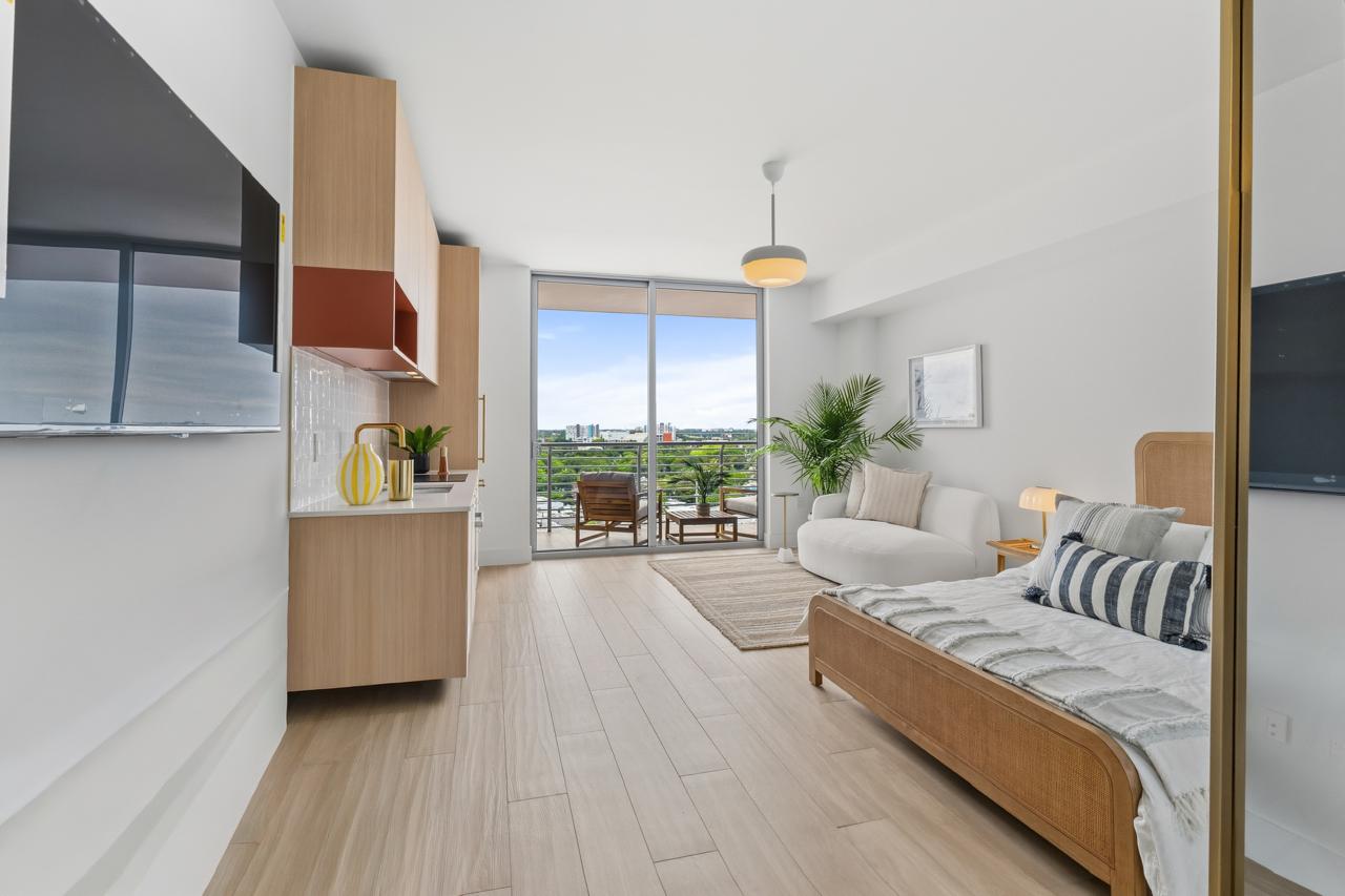 Fully furnished studio living area with balcony access at The Standard Residences Miami